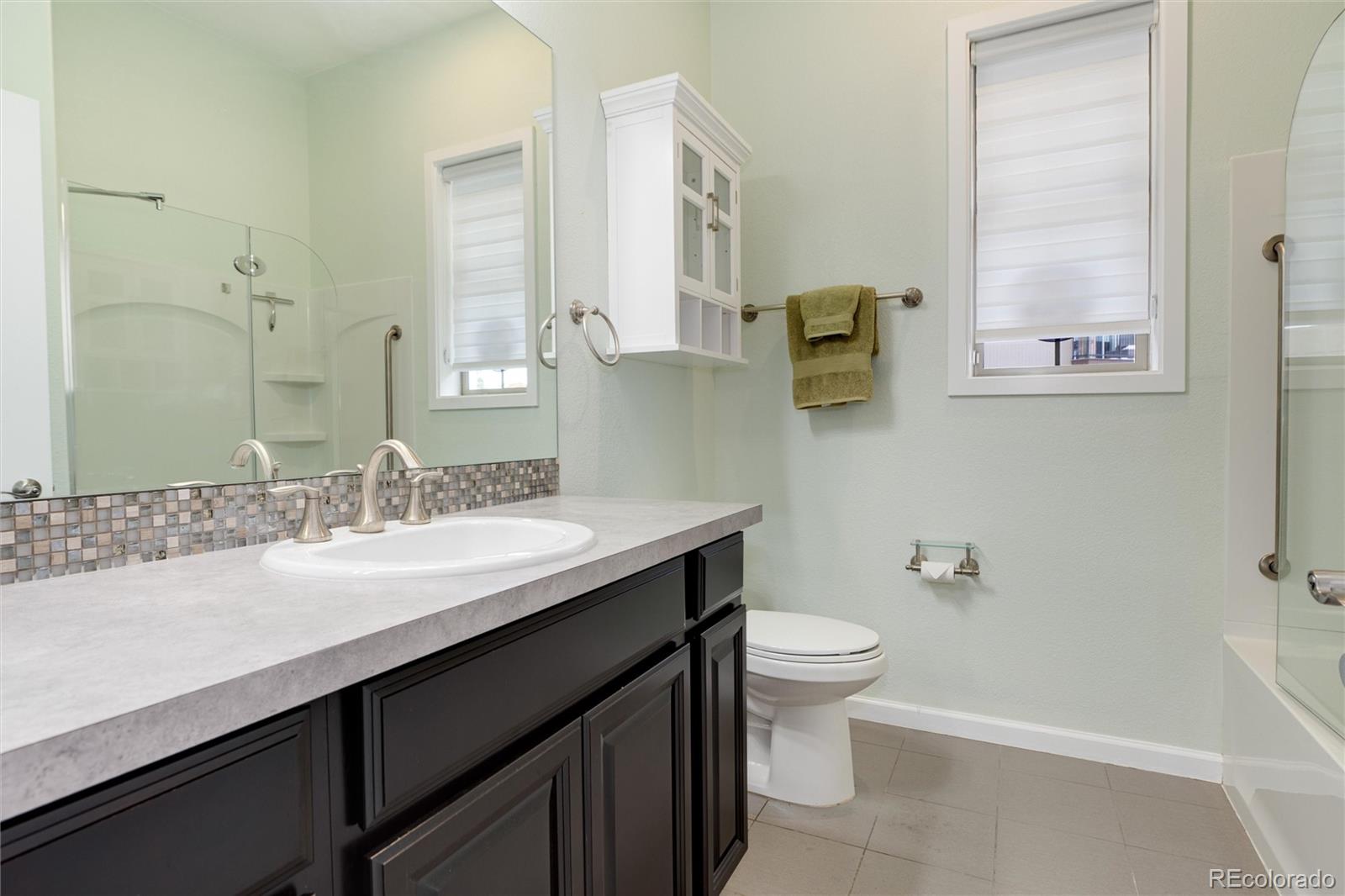 2366 Primo Road, Unit 203 Highlands Ranch, CO 80129 - Photo 32 of 35 a bathroom with a granite countertop sink toilet and shower