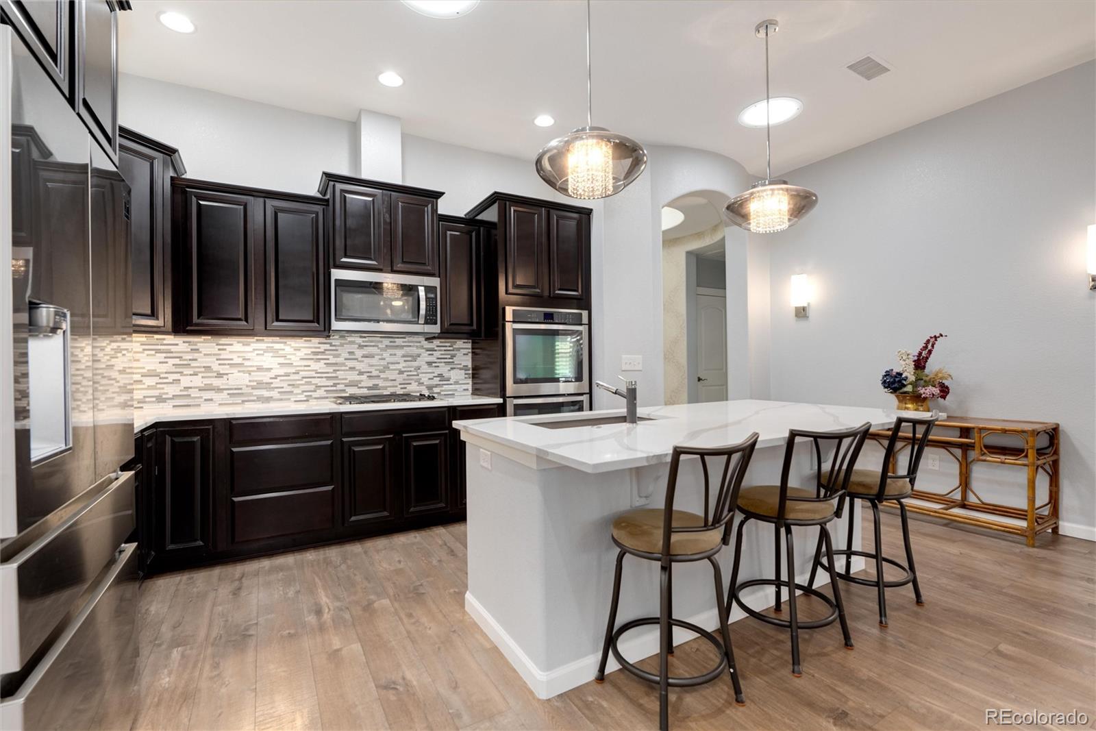 2366 Primo Road, Unit 203 Highlands Ranch, CO 80129 - Photo 7 of 35 a kitchen with stainless steel appliances kitchen island granite countertop a kitchen island a stove and a sink