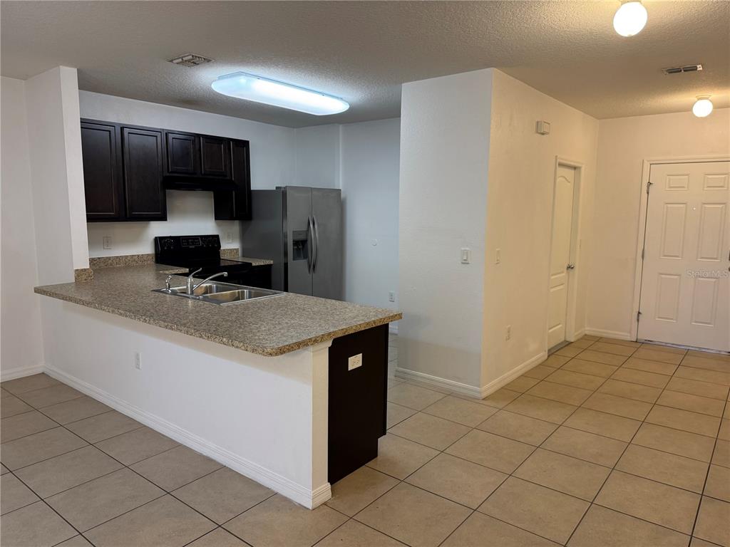 268 Arbor Lakes Drive Davenport, FL 33896 - Photo 7 of 26 a kitchen with stainless steel appliances a sink and a refrigerator