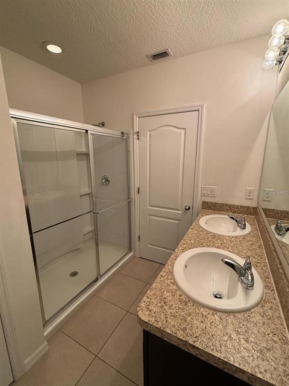 268 Arbor Lakes Drive Davenport, FL 33896 - Photo 10 of 26 a bathroom with a granite countertop sink a mirror and shower