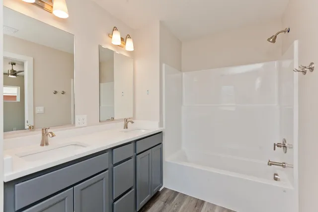 a bathroom with a bathtub shower sink double vanity and a mirror
