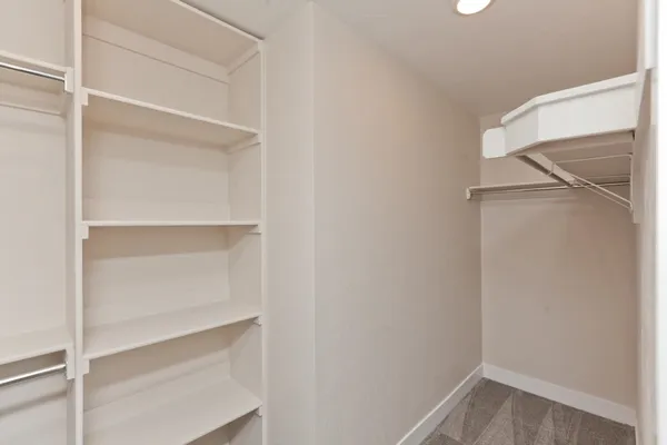 a view of walk in closet with empty racks