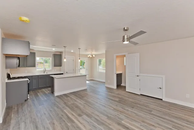 a large white kitchen with a large counter top appliances and cabinets