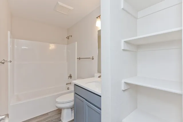 a bathroom with a granite countertop sink a toilet and shower