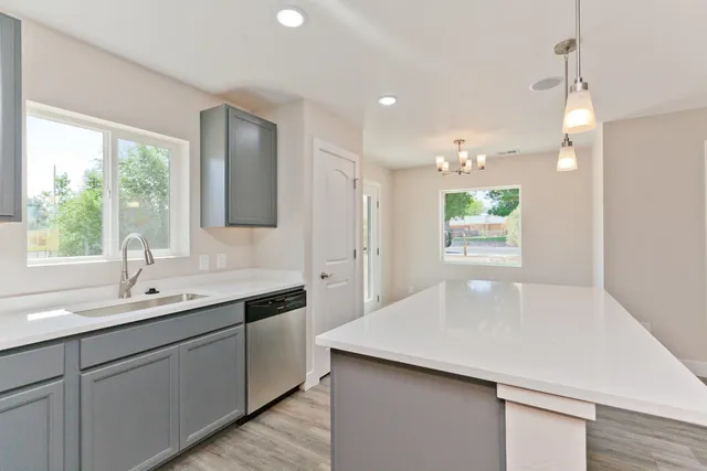 a kitchen with a sink a window and wooden floor