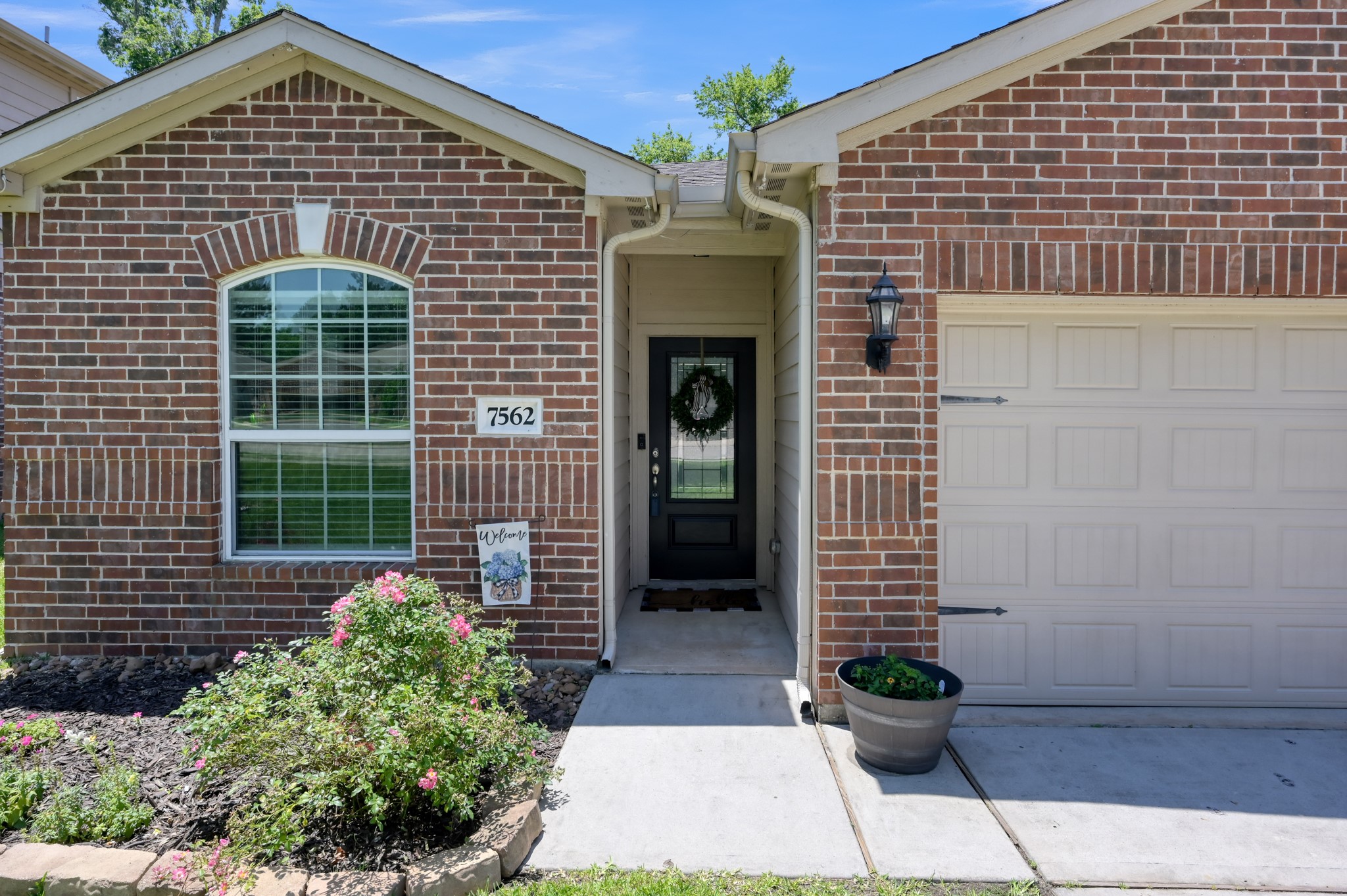 7562 Fettle Lane Conroe, TX 77304 - Photo 2 of 30 Welcoming front entry with charming brick exterior, covered porch, and manicured landscaping.