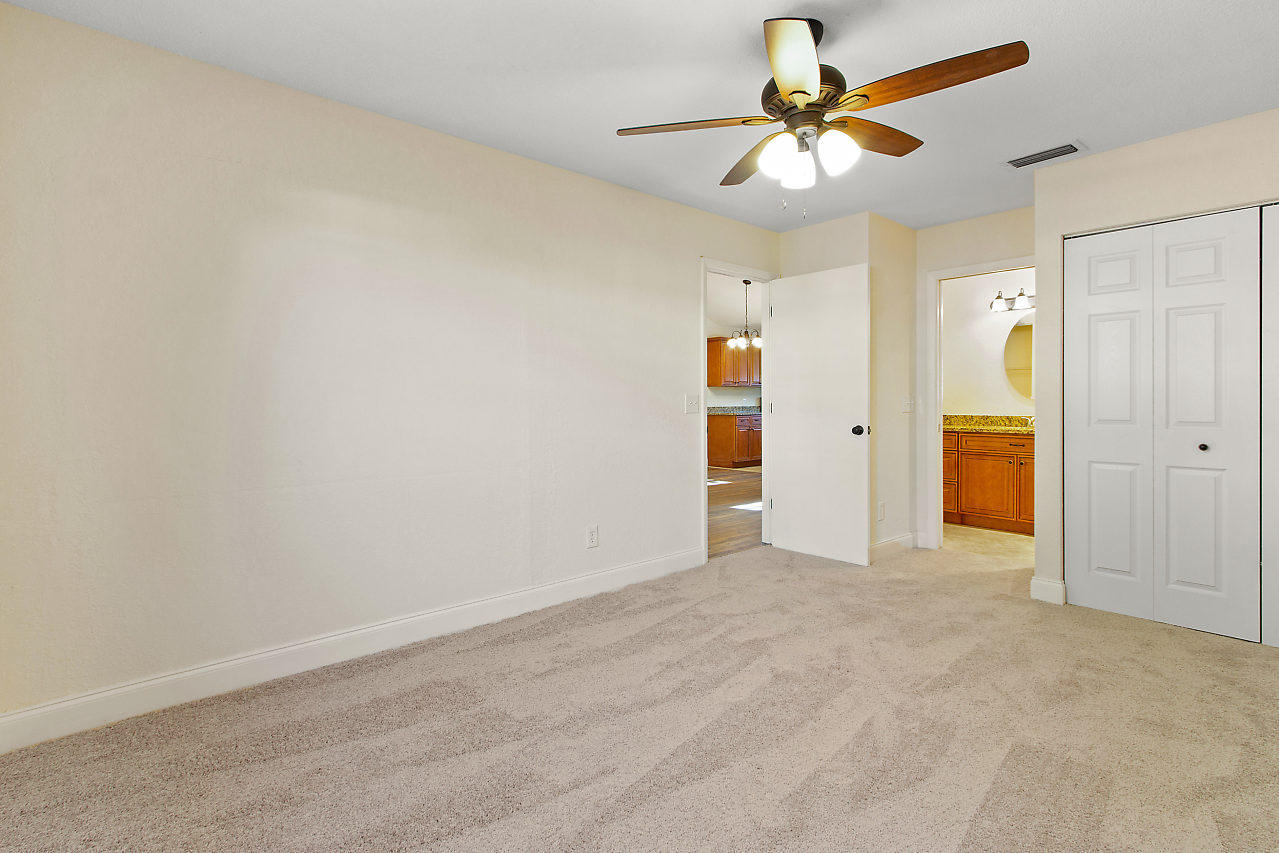 5903 Southeast Mitzi Lane Stuart, FL 34997 - Photo 12 of 22 an empty room with closet and a chandelier fan