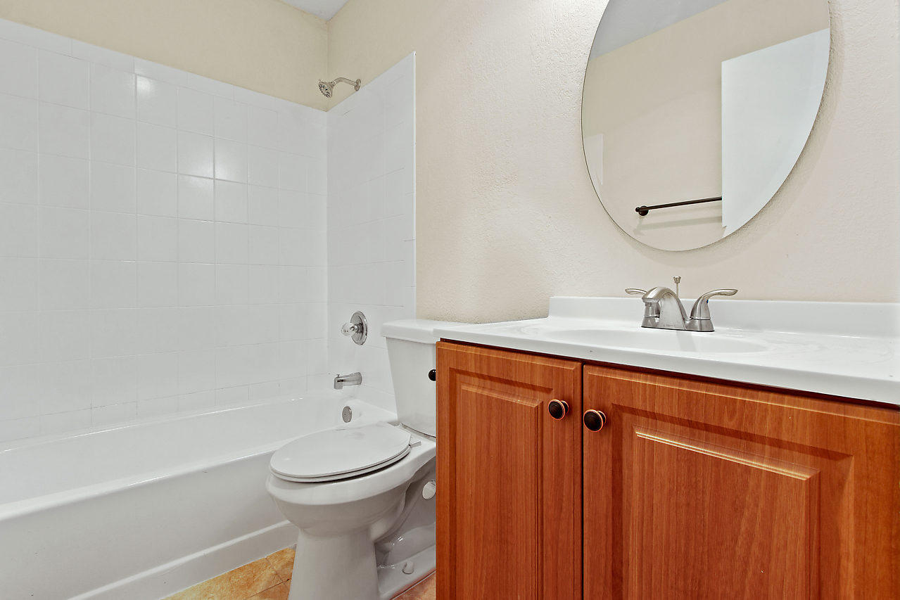 5903 Southeast Mitzi Lane Stuart, FL 34997 - Photo 16 of 22 a bathroom with a sink a toilet and shower