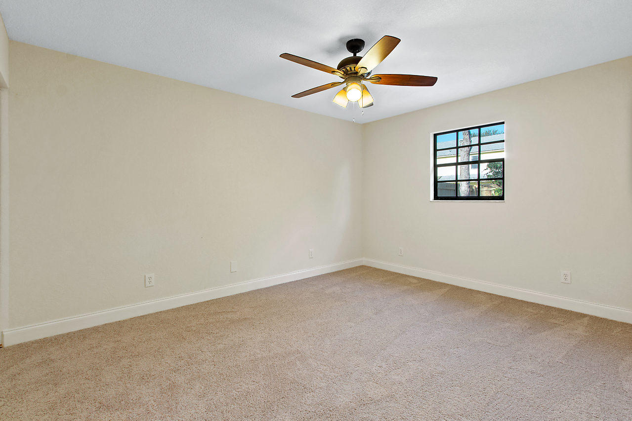 5903 Southeast Mitzi Lane Stuart, FL 34997 - Photo 17 of 22 an empty room with window and ceiling fan