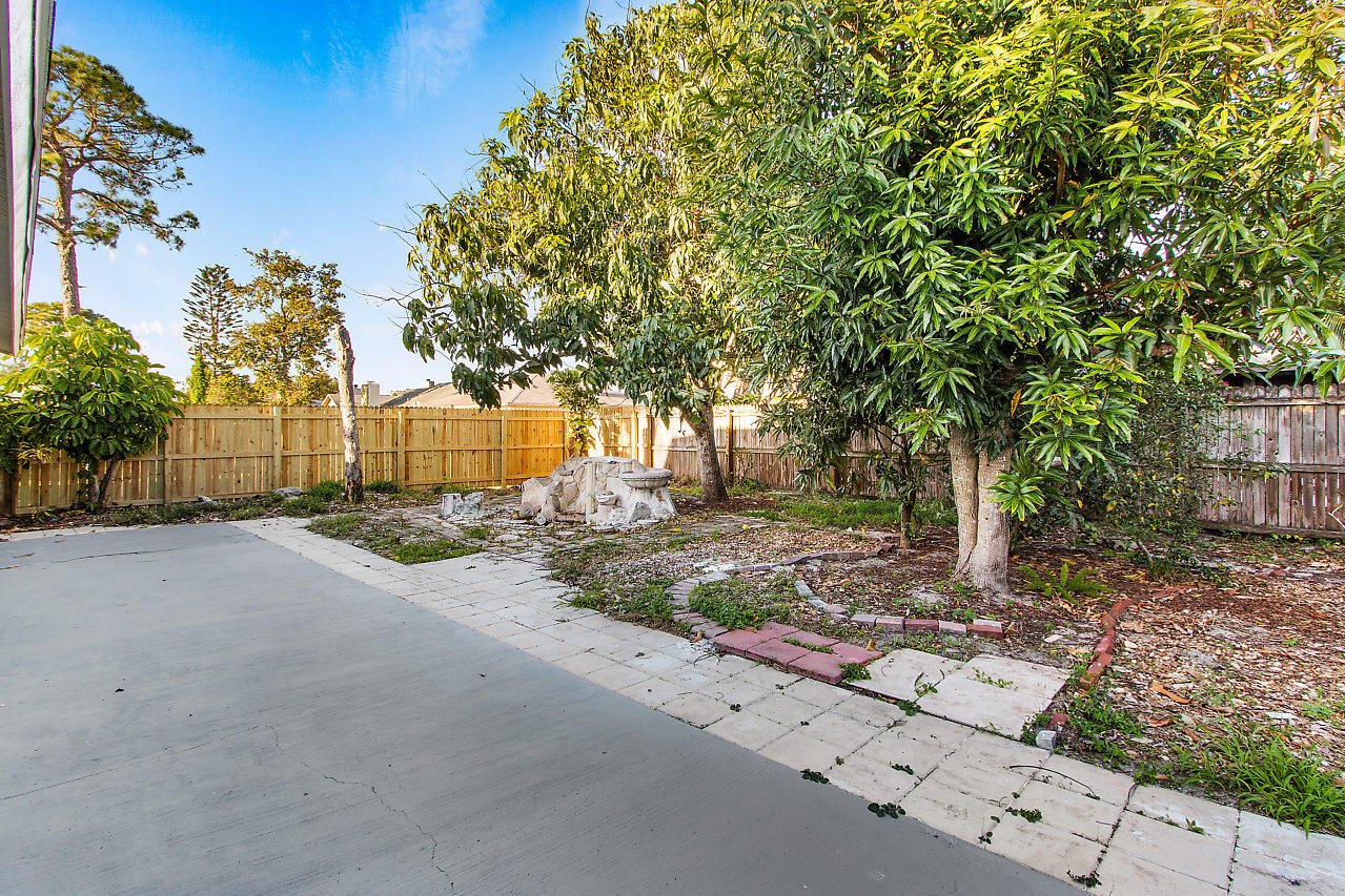 5903 Southeast Mitzi Lane Stuart, FL 34997 - Photo 19 of 22 a view of a backyard with large trees