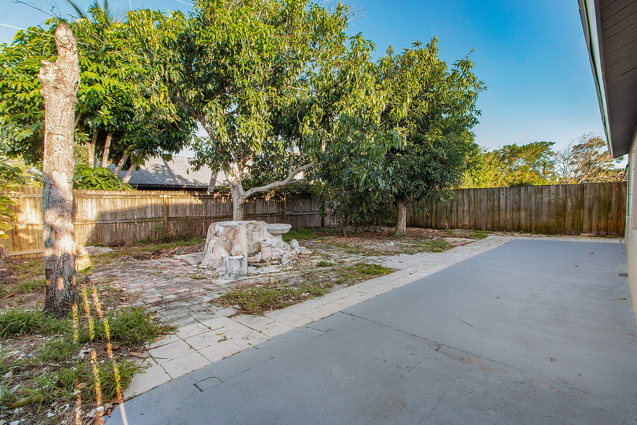 5903 Southeast Mitzi Lane Stuart, FL 34997 - Photo 20 of 22 a view of a backyard with a tree