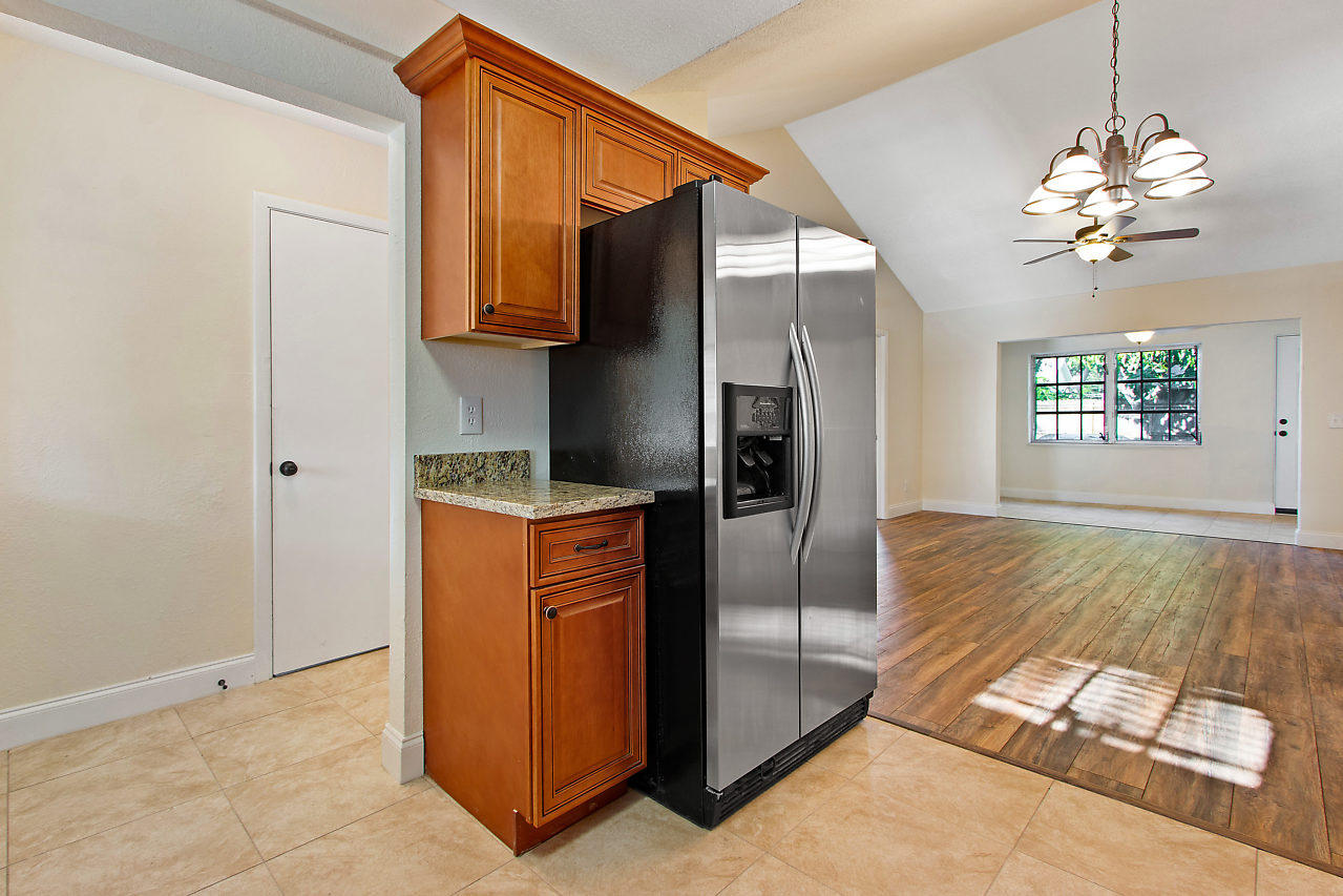 5903 Southeast Mitzi Lane Stuart, FL 34997 - Photo 6 of 22 a kitchen with stainless steel appliances granite countertop a refrigerator and a stove