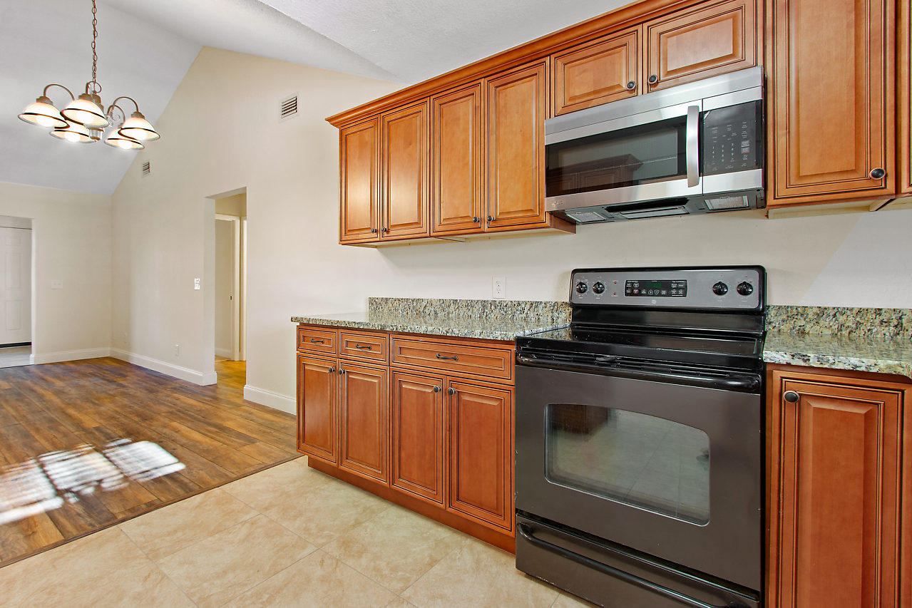 5903 Southeast Mitzi Lane Stuart, FL 34997 - Photo 7 of 22 a kitchen with stainless steel appliances granite countertop a stove microwave and oven