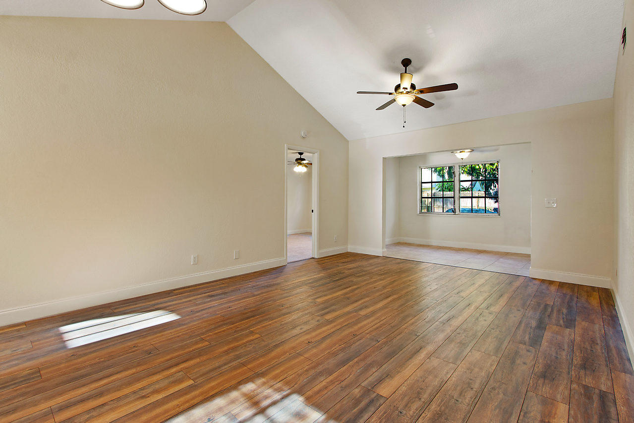 5903 Southeast Mitzi Lane Stuart, FL 34997 - Photo 8 of 22 wooden floor in an empty room with a window