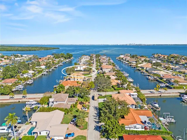 an aerial view of ocean and residential houses with outdoor space