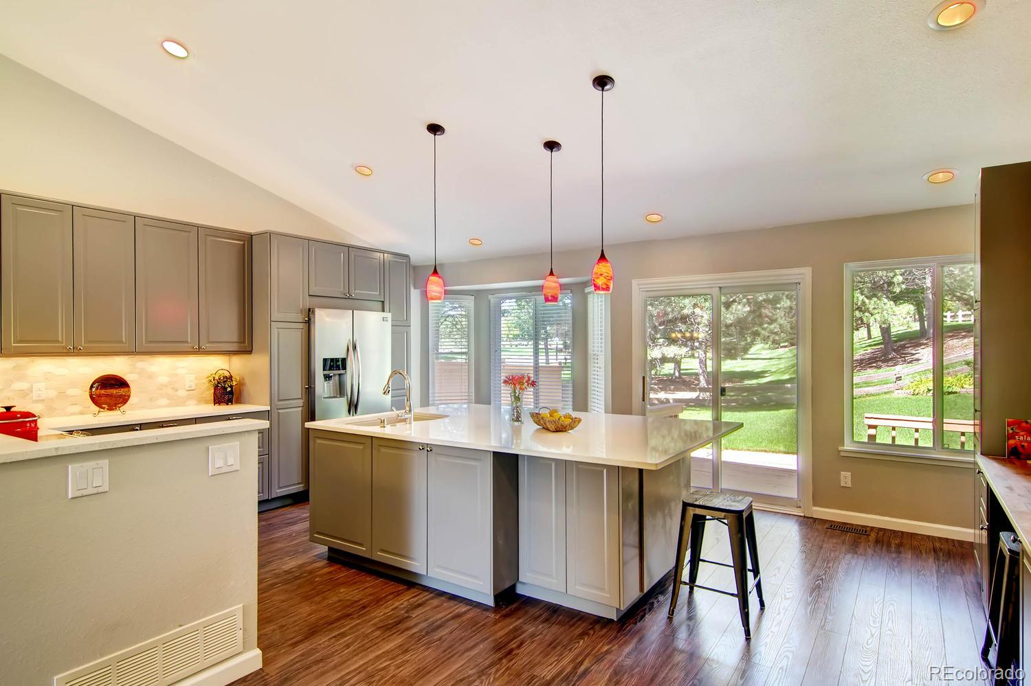 3 Jack Rabbit Place Highlands Ranch, CO 80126 - Photo 8 of 28 a kitchen with stainless steel appliances a sink a stove and a large window