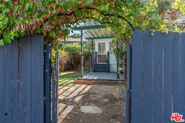 a view of a entrance gate of the house and trees