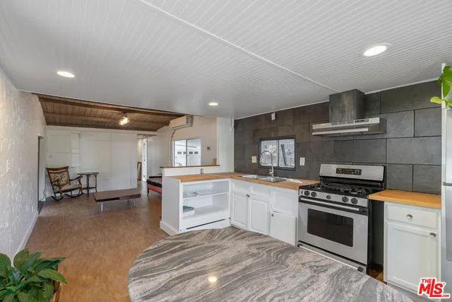 a kitchen with granite countertop a stove top oven and cabinets