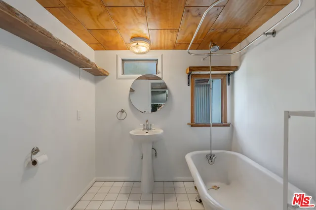 a bathroom with a tub sink and mirror