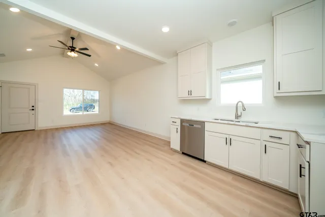 a view of a room with wooden floor and a ceiling fan