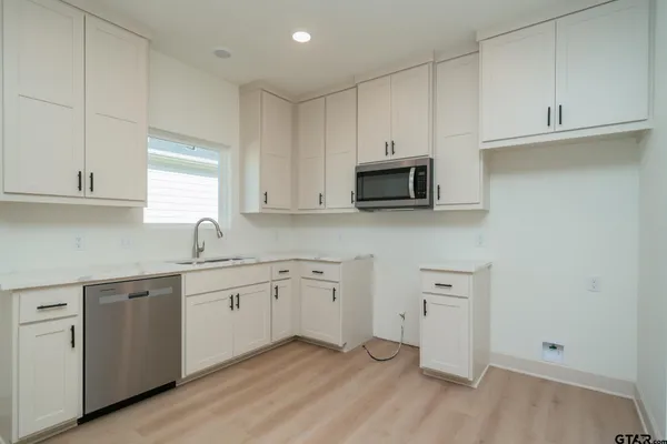 a view of a room with wooden floor and a ceiling fan