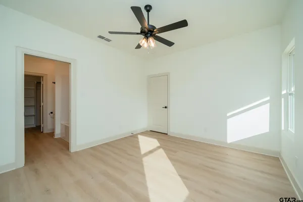 a bathroom with a granite countertop sink vanity mirror and toilet