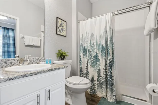 a view of grassy field with benches and trees all around