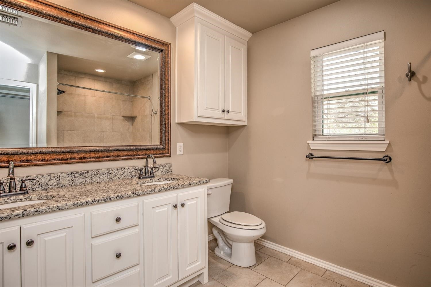 3008 30th Street Lubbock, TX 79410 - Photo 20 of 29 a bathroom with a granite countertop toilet sink and mirror