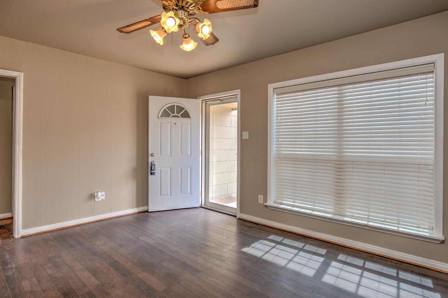3008 30th Street Lubbock, TX 79410 - Photo 2 of 29 wooden floor in an empty room with a window