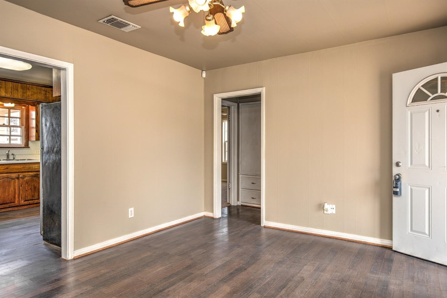 3008 30th Street Lubbock, TX 79410 - Photo 5 of 29 an empty room with wooden floor a chandelier and windows