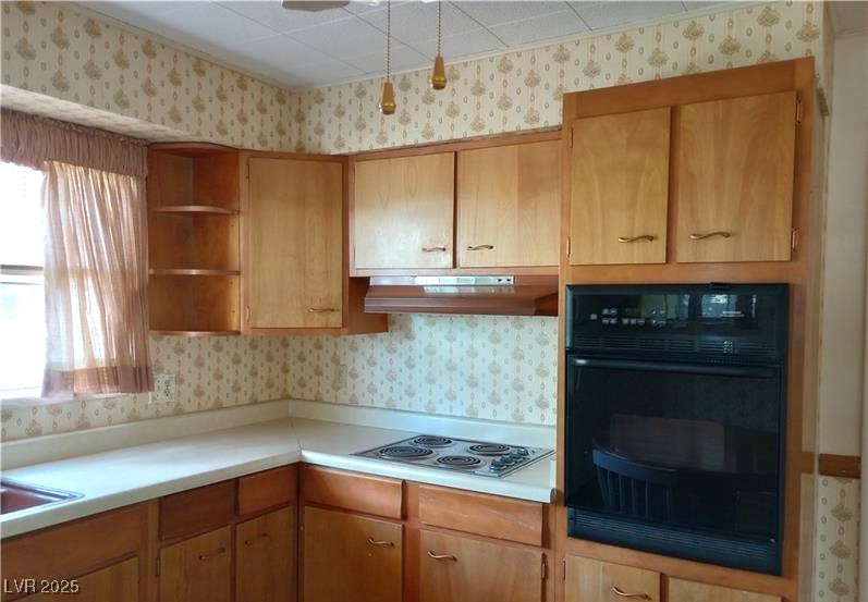 316 Cedar Street Pioche, NV 89043 - Photo 5 of 15 Kitchen with wallpapered walls, light countertops, open shelves, black oven, and stainless steel electric cooktop