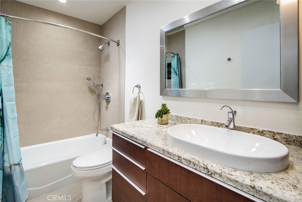 7320 Sherwood Road Joshua Tree, CA 92252 - Photo 31 of 44 a bathroom with a granite countertop sink a toilet a mirror and shower