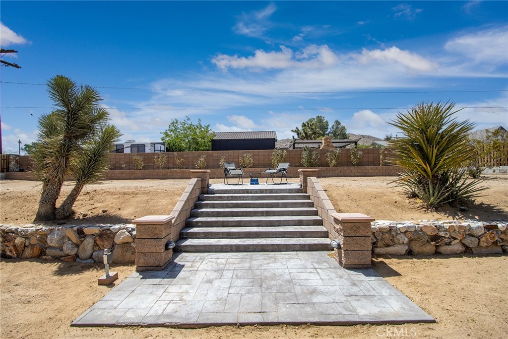 7320 Sherwood Road Joshua Tree, CA 92252 - Photo 39 of 44 a view of a patio with table and chairs with wooden floor and fence