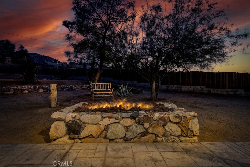 7320 Sherwood Road Joshua Tree, CA 92252 - Photo 43 of 44 a view of patio with table and chairs a barbeque and a floor to ceiling window