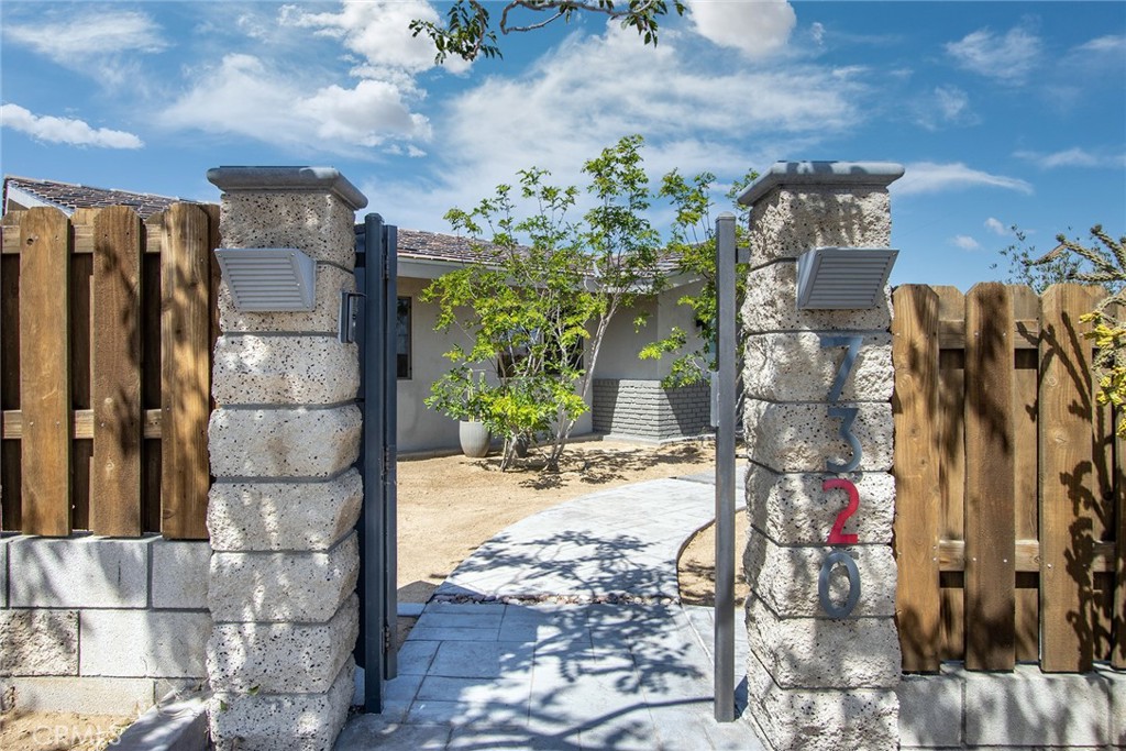 7320 Sherwood Road Joshua Tree, CA 92252 - Photo 6 of 44 a view of a pathway with a buildings in the background