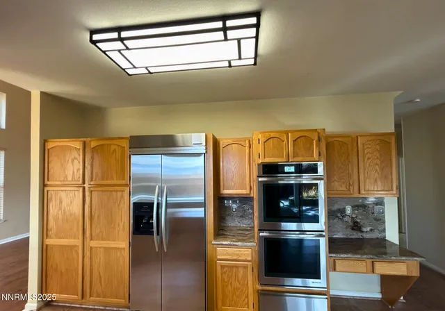 a kitchen with stainless steel appliances a refrigerator and a stove top oven
