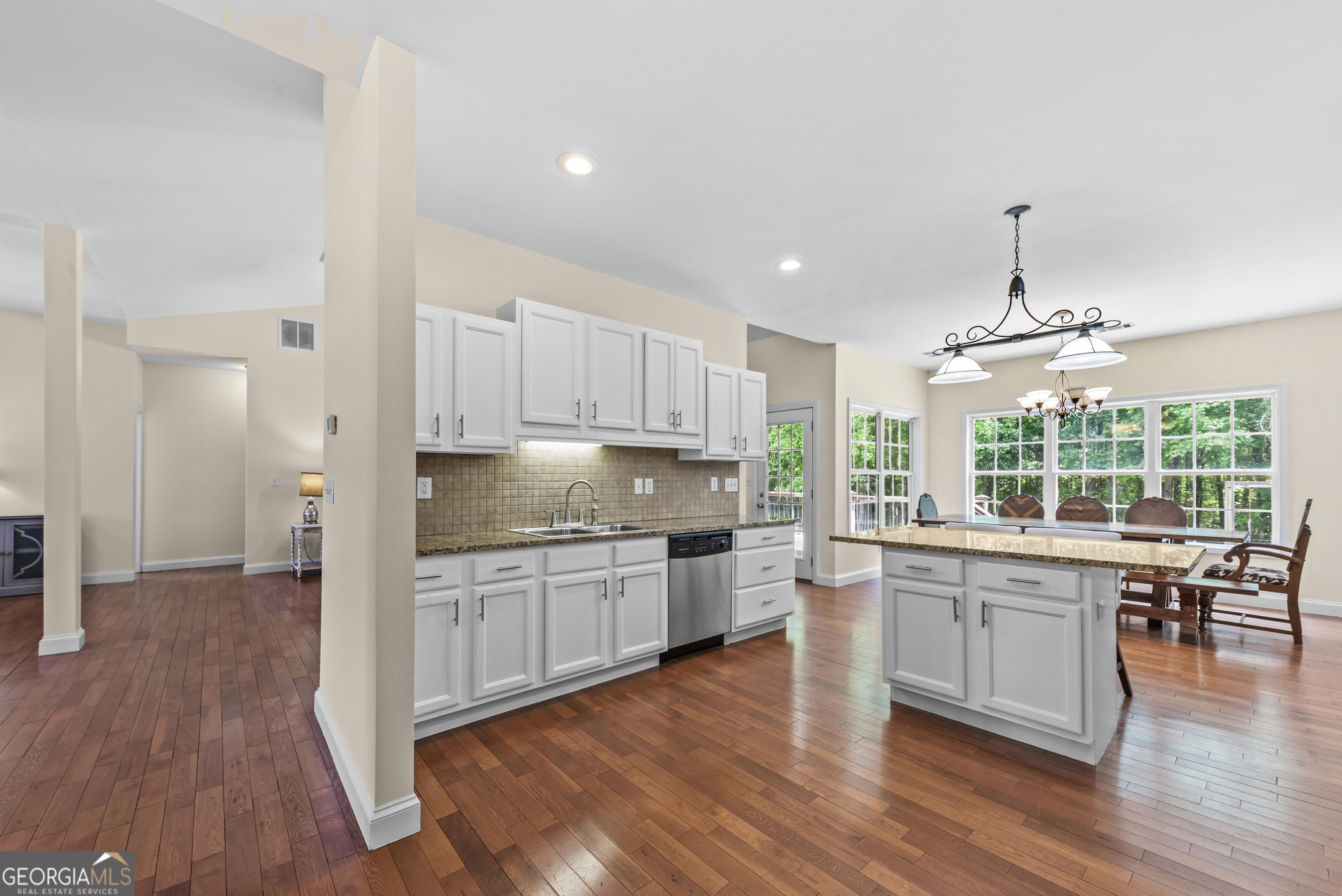 180 Cooper Road Social Circle, GA 30025 - Photo 22 of 51 a kitchen with stainless steel appliances granite countertop wooden floors and white cabinets