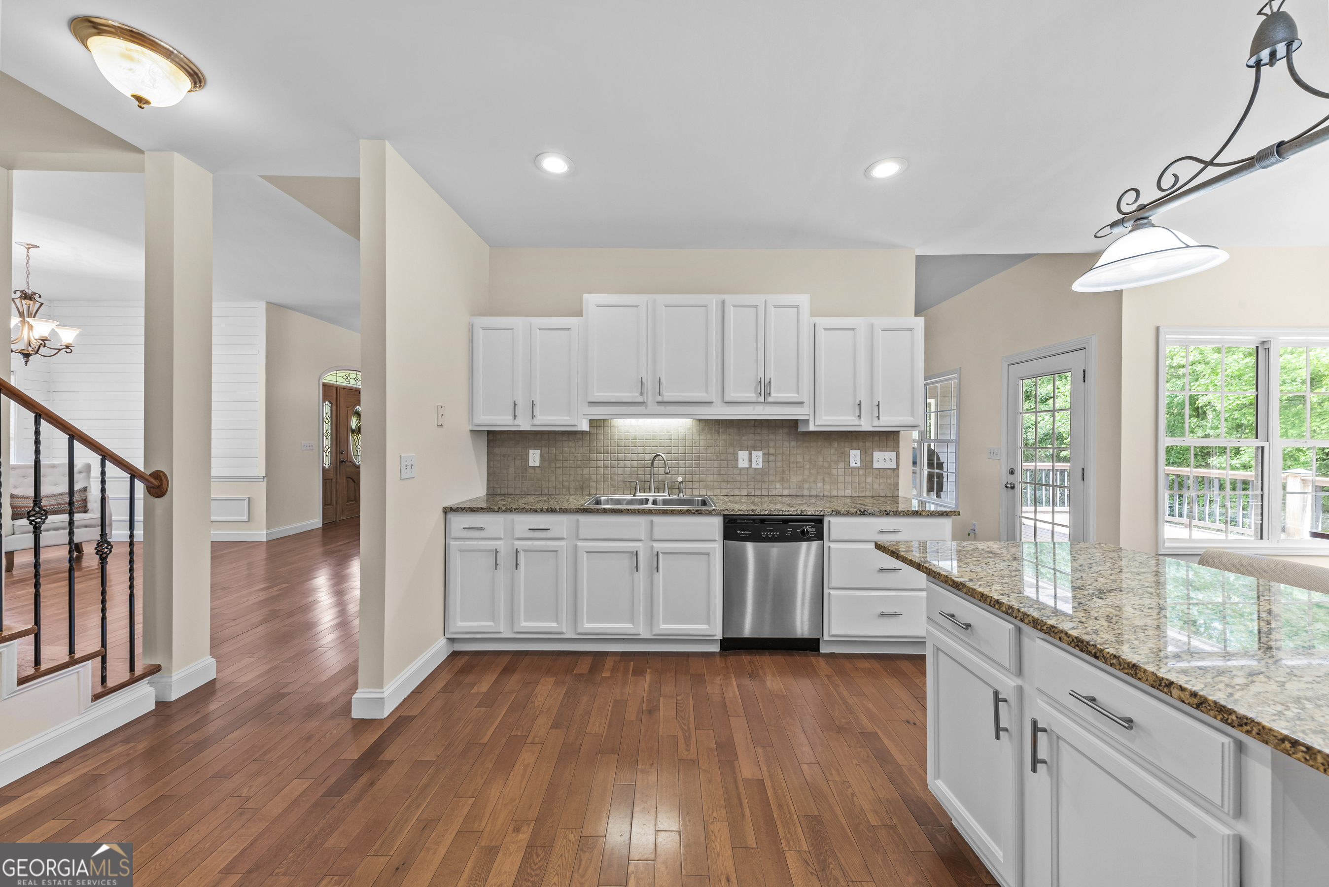 180 Cooper Road Social Circle, GA 30025 - Photo 24 of 51 a kitchen with granite countertop wooden floors stainless steel appliances a sink and a window