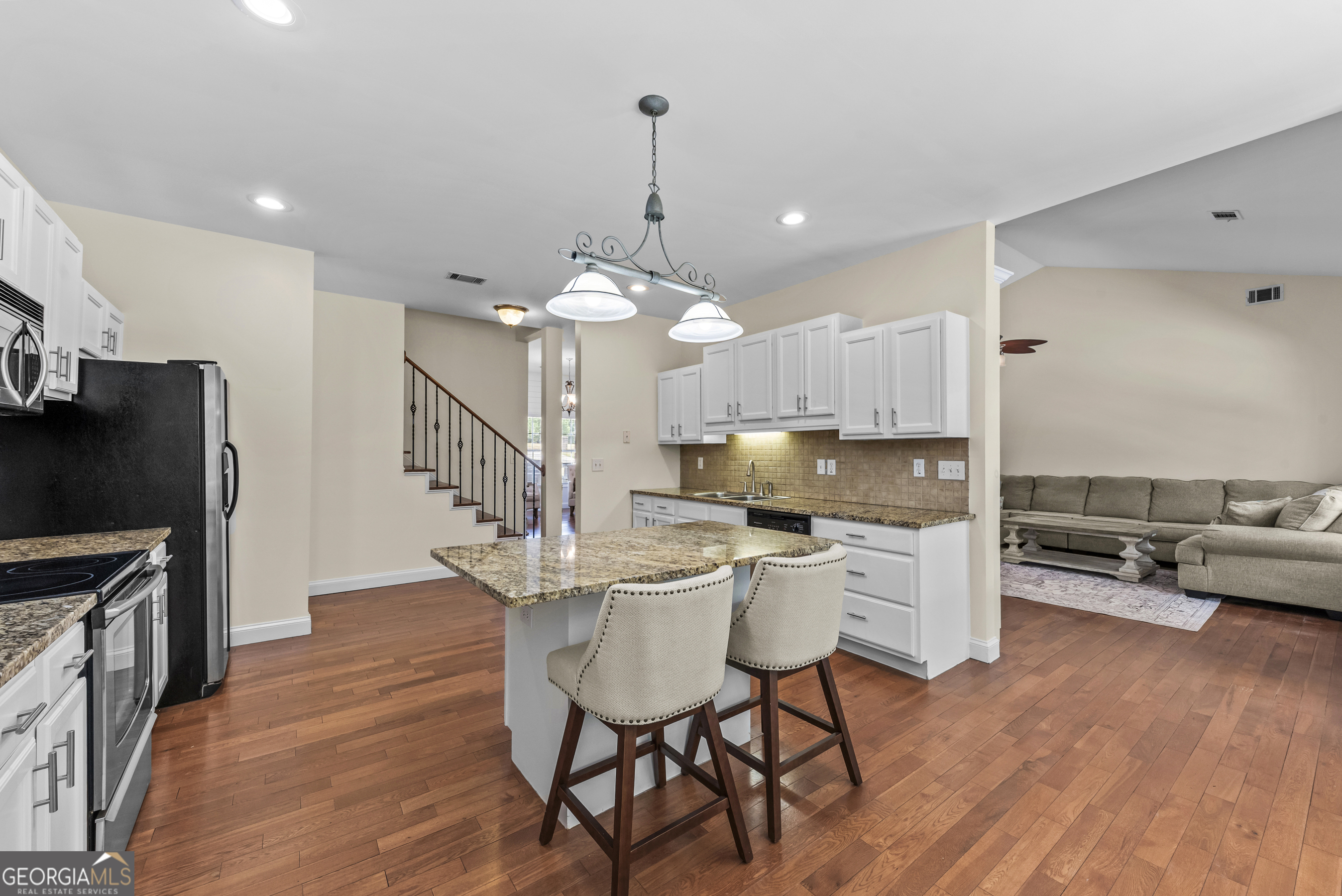 180 Cooper Road Social Circle, GA 30025 - Photo 27 of 51 a kitchen with stainless steel appliances a dining table chairs stove and cabinets