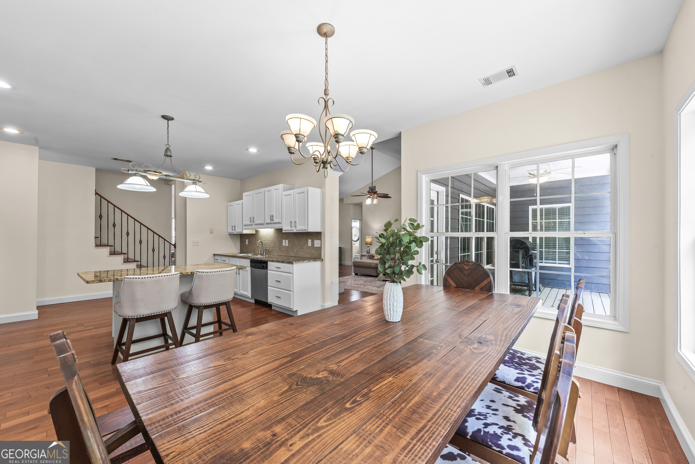 180 Cooper Road Social Circle, GA 30025 - Photo 28 of 51 a dining room with wooden floor a chandelier a wooden table and chairs