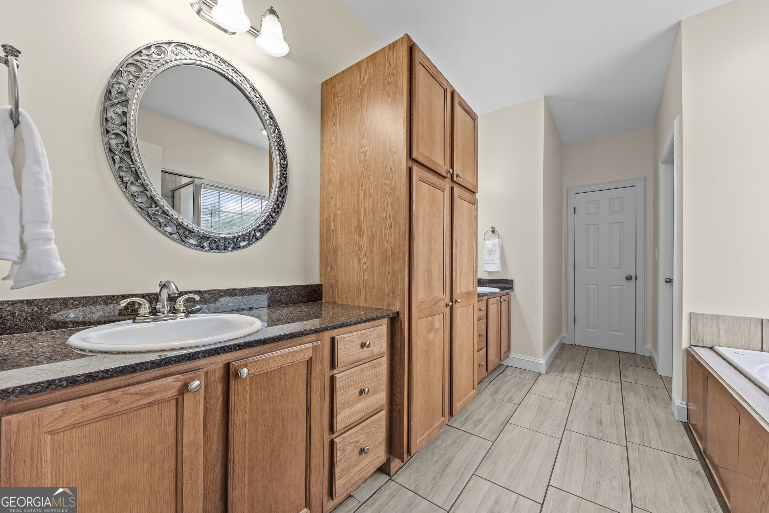 180 Cooper Road Social Circle, GA 30025 - Photo 32 of 51 a spacious bathroom with a granite countertop sink a mirror and a shower