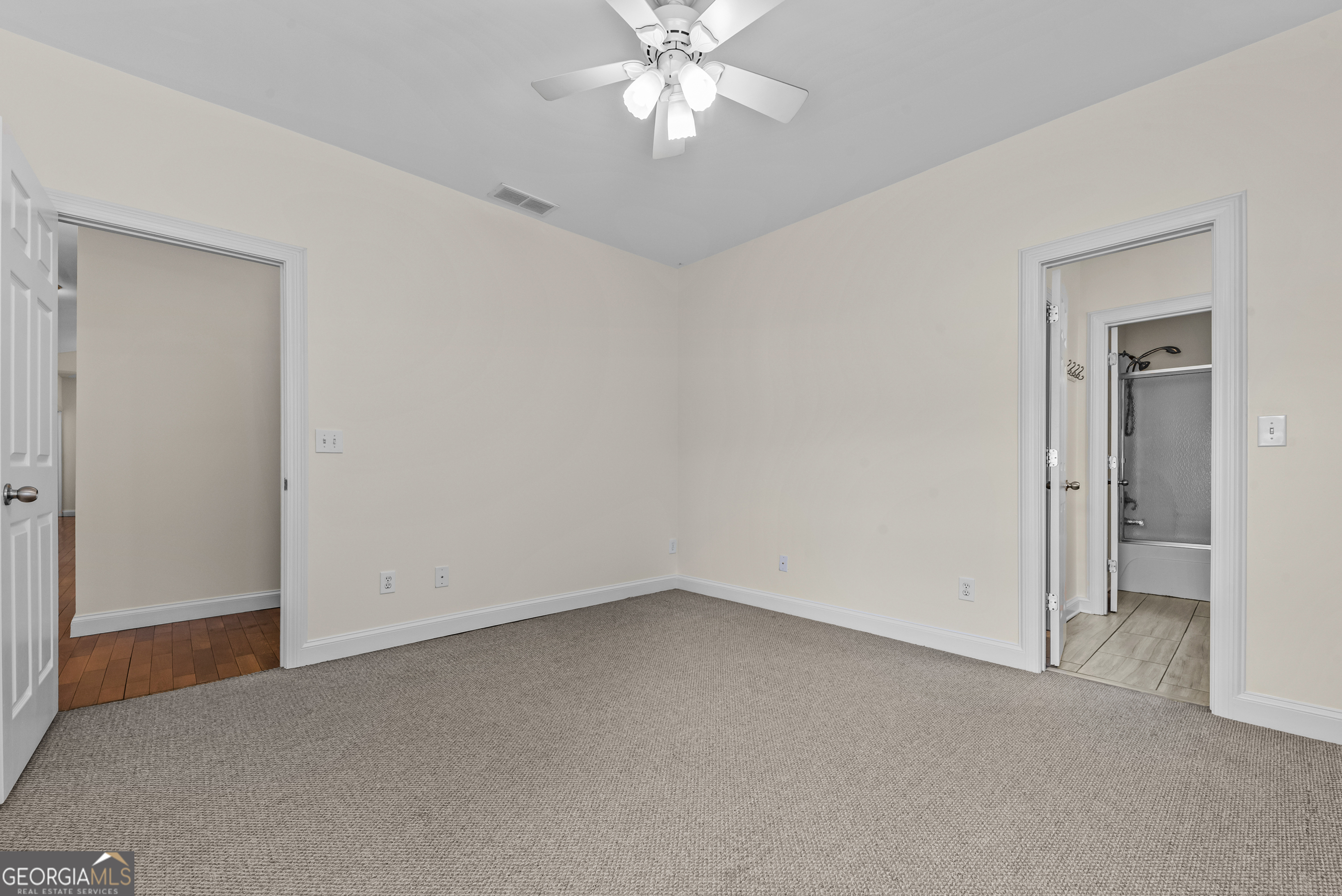 180 Cooper Road Social Circle, GA 30025 - Photo 41 of 51 an empty room with chandelier fan and windows