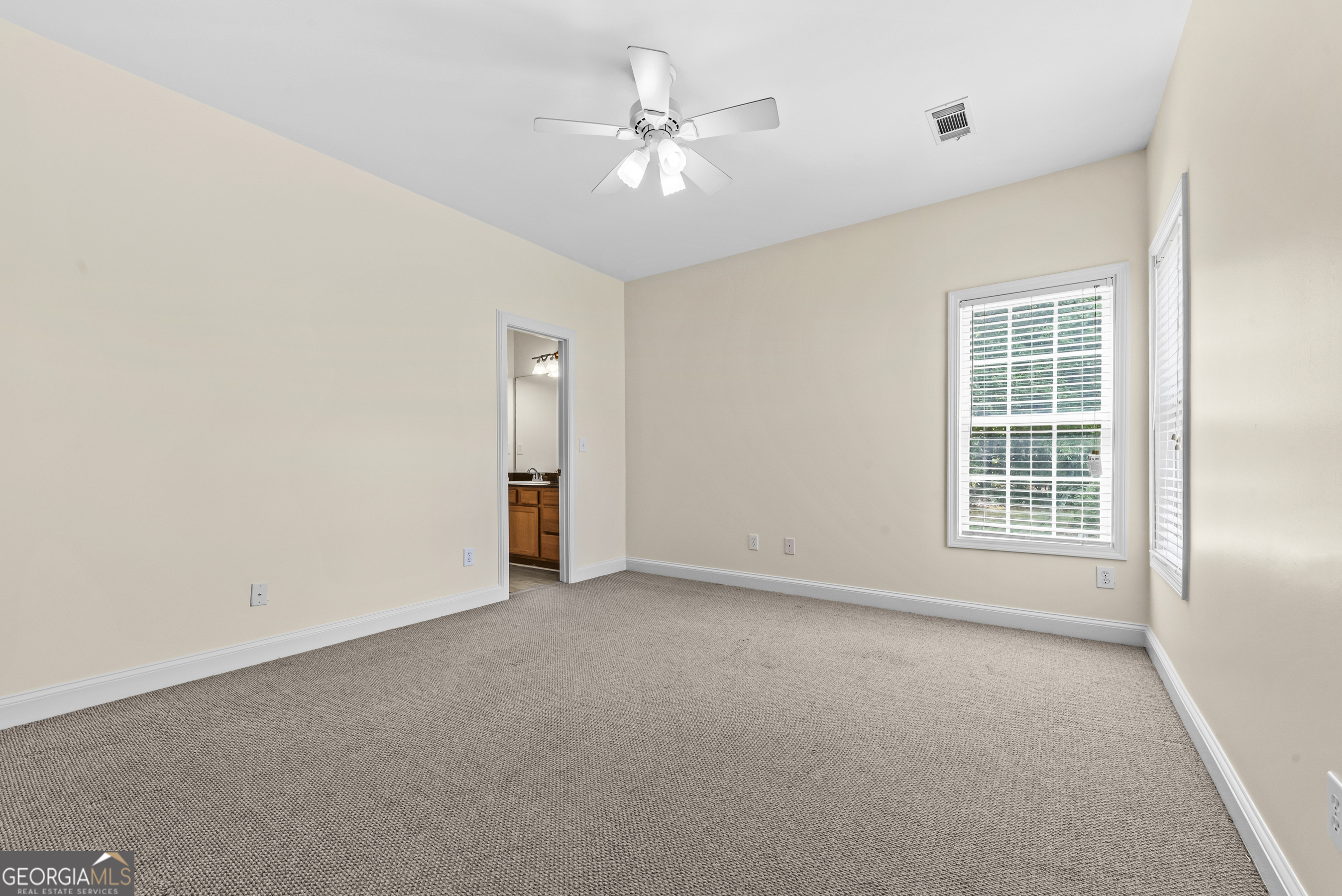180 Cooper Road Social Circle, GA 30025 - Photo 42 of 51 an empty room with windows and ceiling fan