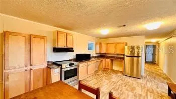 a kitchen with stainless steel appliances granite countertop a refrigerator a stove and a sink