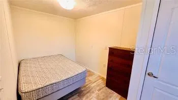 a bedroom with a small bed and a mirror