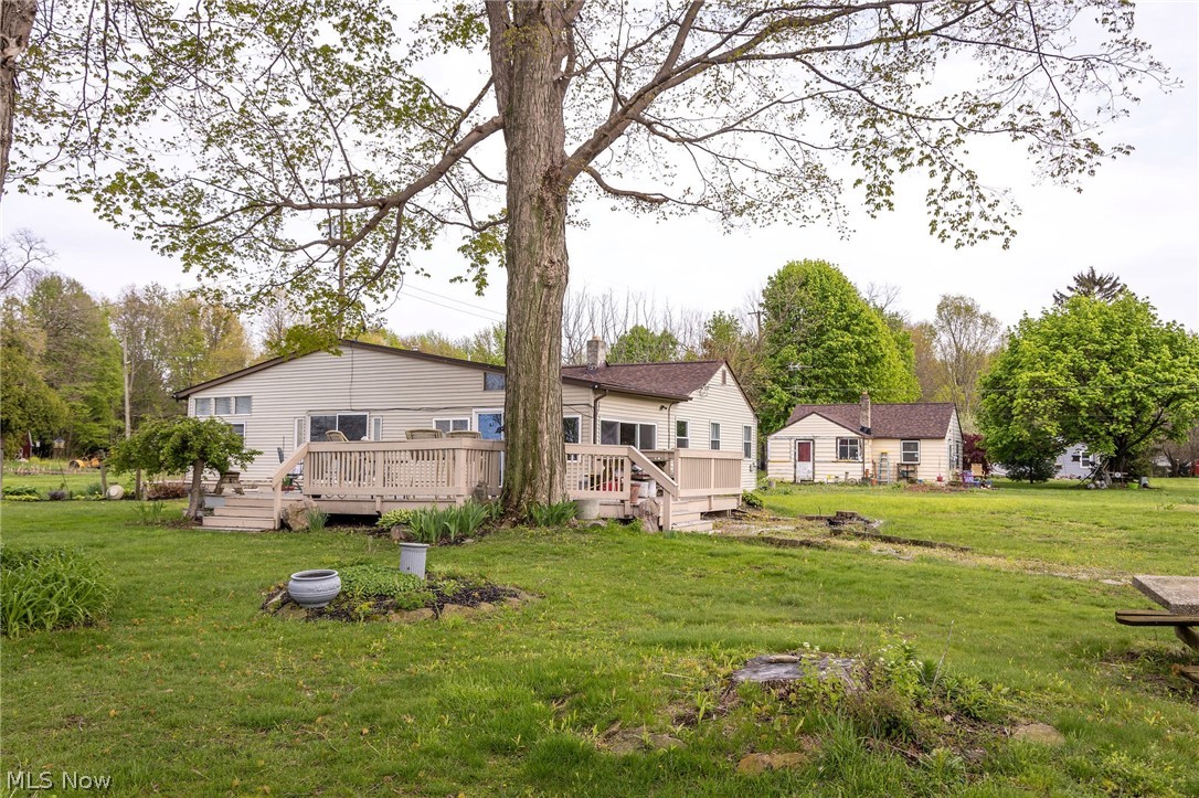 5467 Chapel Road Madison, OH 44057 - Photo 3 of 50 Expansive grassy yard area with mature trees and a multi-level deck