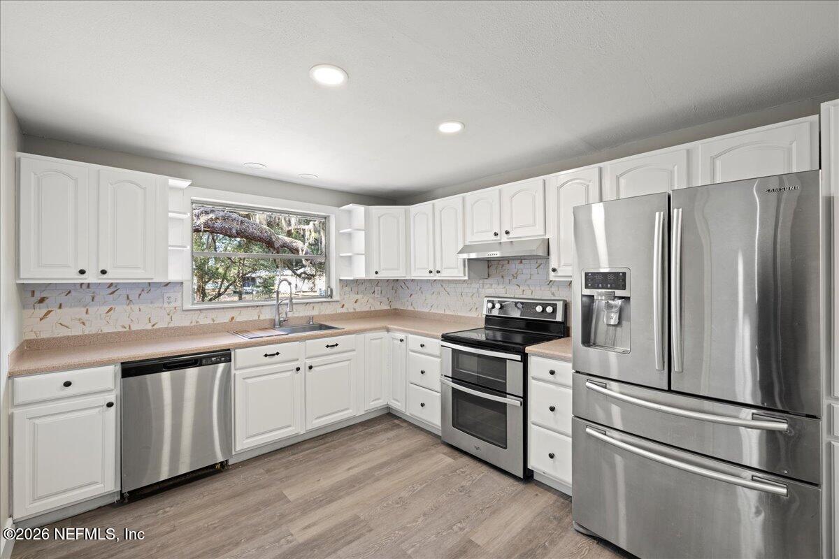 242 Taylor Fury Road Pomona Park, FL 32181 - Photo 11 of 40 a kitchen with granite countertop white cabinets and stainless steel appliances