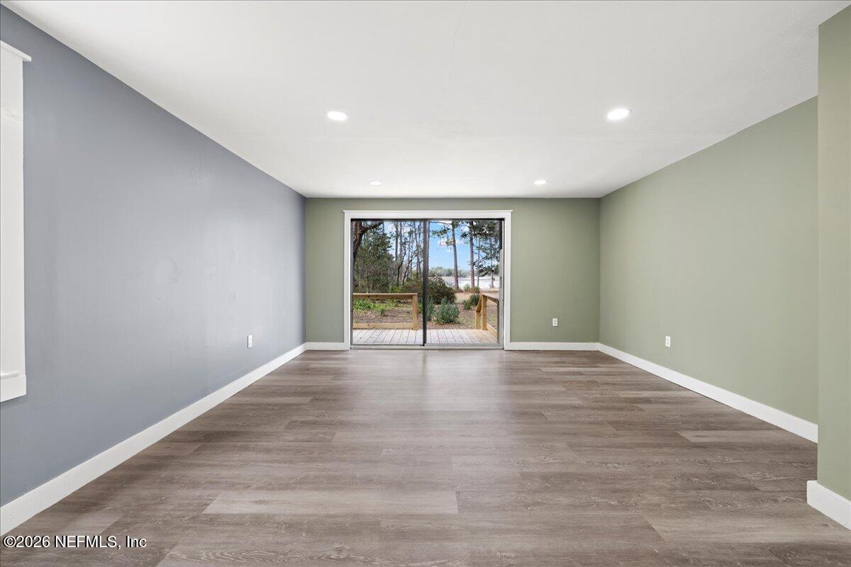 242 Taylor Fury Road Pomona Park, FL 32181 - Photo 21 of 45 a view of an empty room with wooden floor and a window