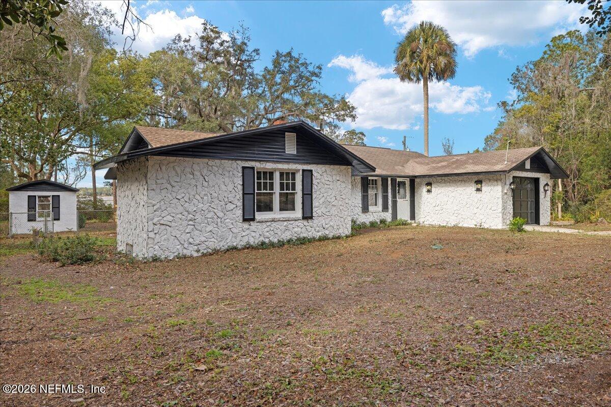 242 Taylor Fury Road Pomona Park, FL 32181 - Photo 42 of 45 a front view of a house with a garden and tree