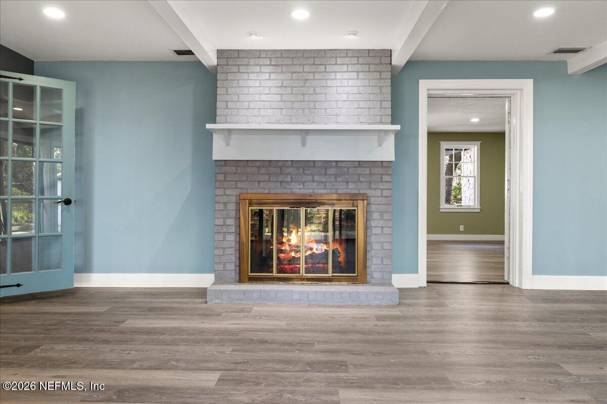 242 Taylor Fury Road Pomona Park, FL 32181 - Photo 8 of 40 an empty room with wooden floor a fireplace and entryway